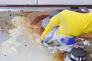 Close up of woman cleaning cooker at home kitchen