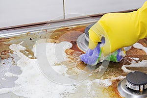 Close up of woman cleaning cooker at home kitchen