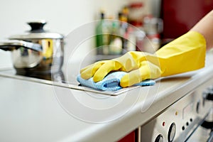 Close up of woman cleaning cooker at home kitchen