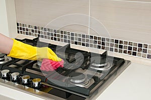 Close up of woman cleaning cooker at home kitchen