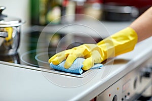 Close up of woman cleaning cooker at home kitchen