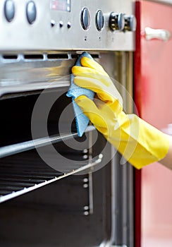 Close up of woman cleaning oven at home kitchen