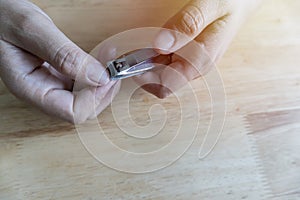 Close-up of woman clipping her nails with nail clippers, after cutting short nails, dark, rough skin