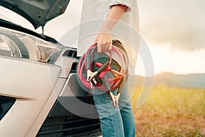 Close up Woman connecting battery cable copper wire for jumper repair and maintenance