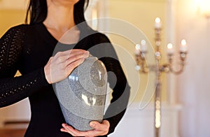 Close up of woman with cremation urn in church