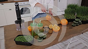 Close-up of a woman cutting a grapefruit on a wooden cutting board.