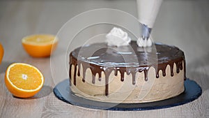 Close-up of woman decorating cake with a cream
