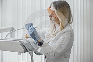 Close up of woman dentist checking dental equipment, dental instruments.