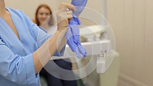 Close-up of a woman dentist wears sterile gloves.