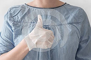 Close-up woman doctor hands in white medical rubber gloves on heart blue coat background. Stop virus and coronovirus