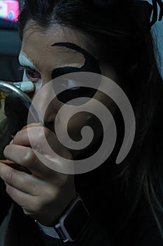 Close-up of woman doing scary makeup to celebrate Halloween or Day of the Dead