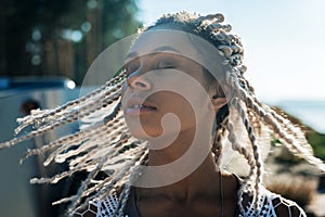 Close up woman with dreadlocks feeling free and relaxed in nature