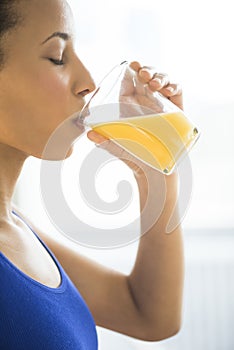 Close-Up Of Woman Drinking Fresh Orange Juice