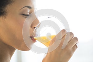 Close-Up Of Woman Drinking Orange Juice