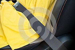 Close up of woman driver in yellow summer dress wearing seatbelt driving a car