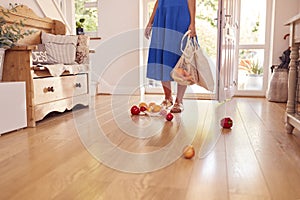 Close Up Of Woman Dropping Fresh Produce On Floor After Returning From Shopping Trip