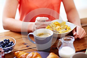 Close up of woman eating cereals with coffee