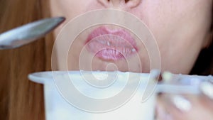 Close up woman eating cottage cheese with chocolate cereal. Close up female mouth eats for breakfast yogurt dairy