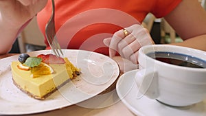 close-up. woman eating with a fork a piece of vegan mango pie