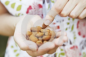 Close Up Of Woman Eating handful Of Almonds