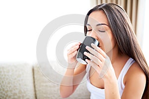 Close up of woman enjoying a warm drink.