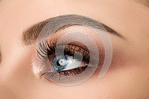 Close-up of woman eye with beautiful brown smokey eyes makeup photo