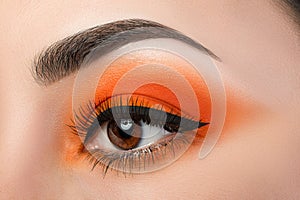 Close-up of woman eye with beautiful orange smokey eyes