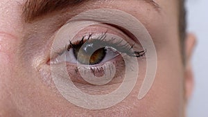 Close-up woman eye looking into camera, hypoallergenic waterproof cosmetics photo