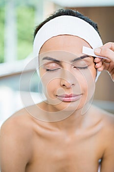 Close-up of woman with eyes closed while receiving face waxing