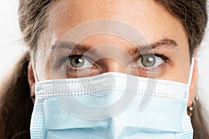 Close-up of woman eyes wearing surgical or medical mask covid19