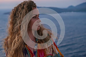 Close up of woman face looking at sunset and sea view from terrace of luxury holiday villa