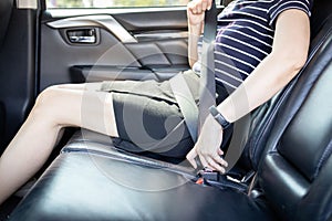 Close up,woman fastening her seat belt,prevent injury or loss,sit in back seat of a car,wearing seat belt for safety in vehicle