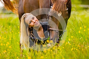 Close-up of woman feeding her arabian horse with snacks in idyllic meadow