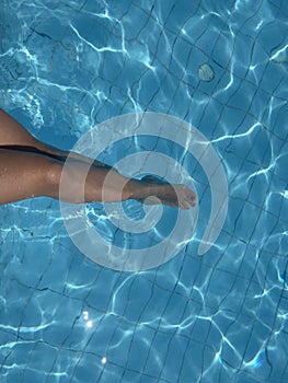 close up woman feet in swimming pool.summer holiday concept.