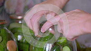 Close-up of a Woman Filling a Glass Bank with Fresh Cucumbers for Cooking