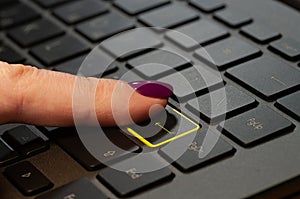 Close up woman finger pressing enter button on the laptop keyboard