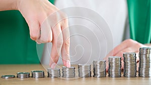 Woman fingers going up on bar chart collected of silver coins photo