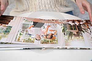 Close up. woman flips through photo book from family pregnancy photo shoot
