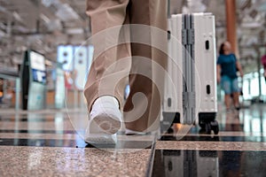 Close-up woman foot walking with suitcase , check in at International airport , vacation travel and transportation concept