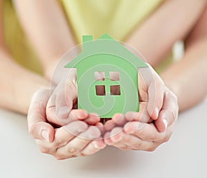 Close up of woman and girl hands with paper house