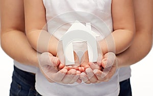 Close up of woman and girl hands with paper house