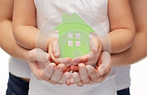 Close up of woman and girl hands with paper house