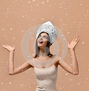 Close up of woman girl in traditional russian cap kokoshnik holding snow in hands in studio,