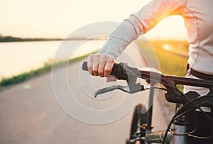 Close up woman hand on the bicycle handlebars
