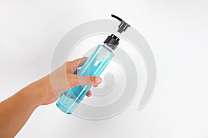 Close up woman hand Holding alcohol gel from pump bottle on white background.Coronavirus or COVID 19 prevention concept with Washi