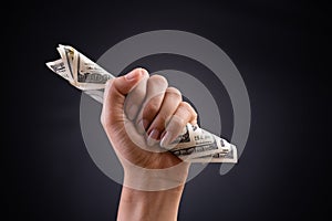 Close up woman hand holding American dollar in the dark background. Business finances, savings and bankruptcy concept