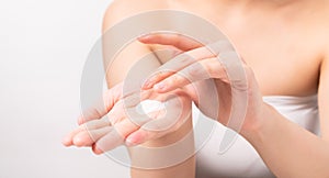 Close up of woman hand holding and applying moisturiser, Body lotion,  on white background.