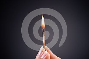 Close up woman hand holding a burning match