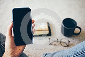 Close-up of woman hand holding cell phone in blue case and using internet, doing calls, online shopping, checking e-mail, working