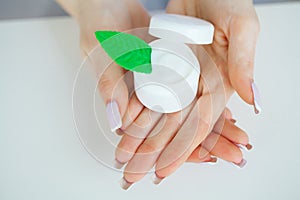 Close-up of a woman hand holding a container of moisturizer cream